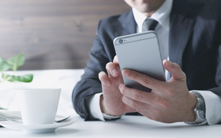 スマートフォンを確認するビジネスパーソン