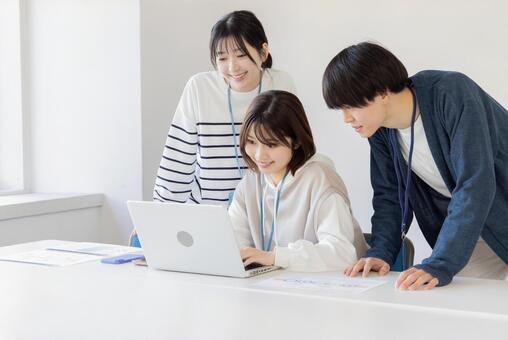 チームでノートパソコンを確認する様子